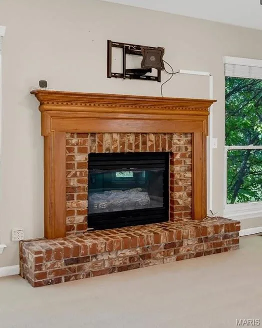 Gas log fireplace has wood mantle and brick hearth surround. — 18 Country Bluff Court, St Charles, MO 63301