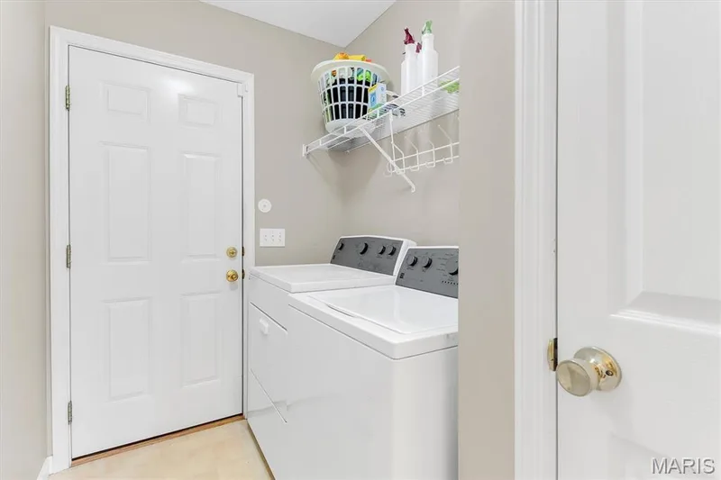 Main floor laundry has closet, washer & dryer (stays) and storage rack. — 18 Country Bluff Court, St Charles, MO 63301