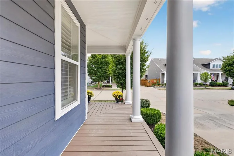 Covered porch entry featuring composite wood-finish decking, white architectural columns, and fiber cement siding — 3708 Broad Street, St Charles, MO 63301