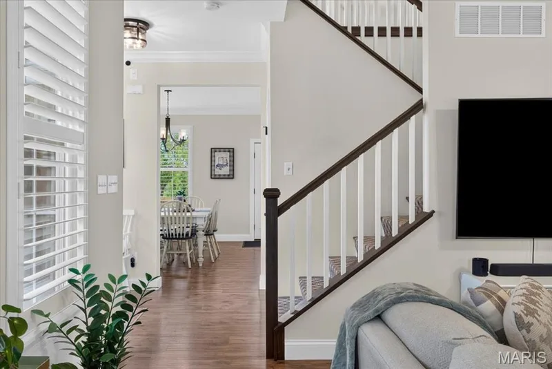 Hardwood-finish flooring, white window shutters, staircase with white balusters and dark wood handrail, recessed lighting, and crown molding — 3708 Broad Street, St Charles, MO 63301