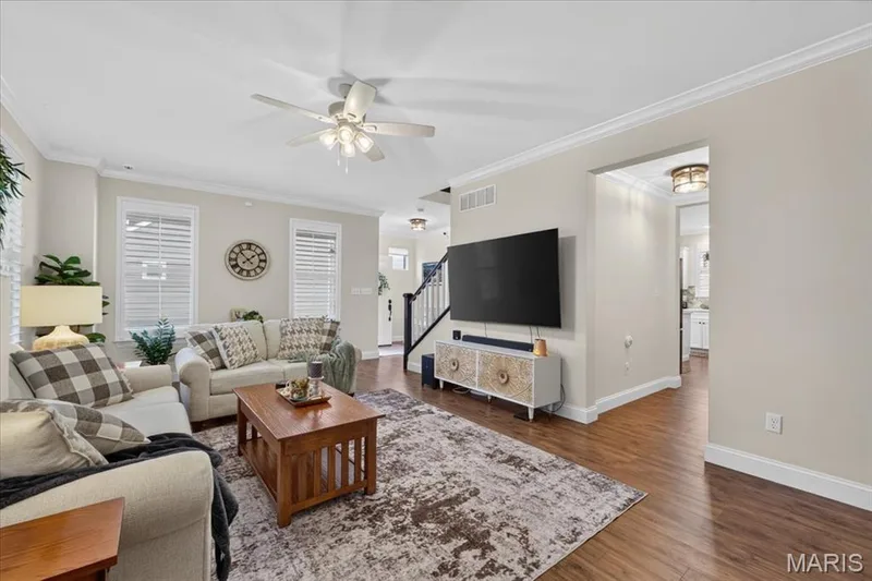 Wood-finish flooring throughout, crown molding, white window blinds, ceiling fan with integrated lighting, and a wide entryway — 3708 Broad Street, St Charles, MO 63301