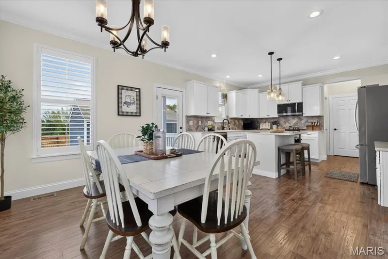 Hardwood-finish flooring, white shaker cabinetry, stainless steel appliances, herringbone tile backsplash, and recessed lighting — 3708 Broad Street, St Charles, MO 63301