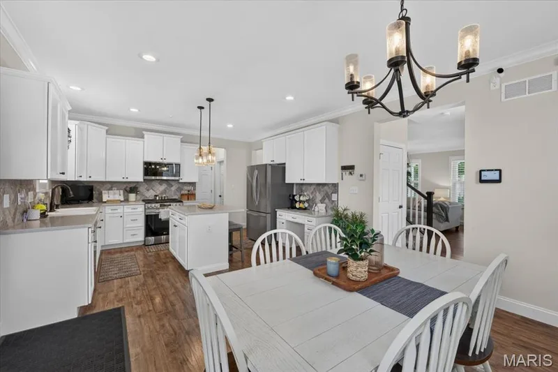 Open-concept kitchen with white cabinetry, stainless steel appliances, and a central island with pendant lighting — 3708 Broad Street, St Charles, MO 63301