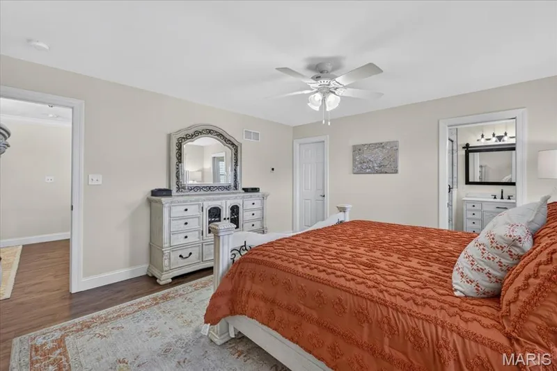 Neutral paint tones, ceiling fan, wood-finish flooring, white trim, and a white interior door — 3708 Broad Street, St Charles, MO 63301
