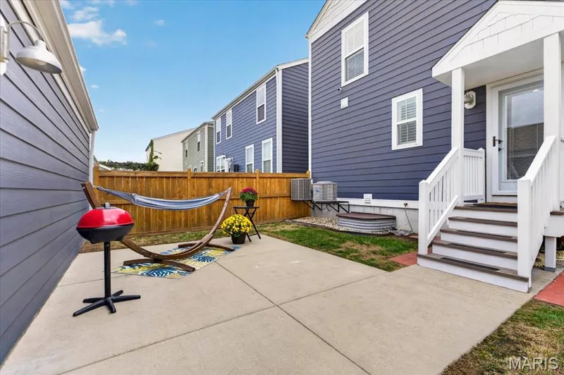 Concrete patio with a wood privacy fence and a white-railed porch — 3708 Broad Street, St Charles, MO 63301