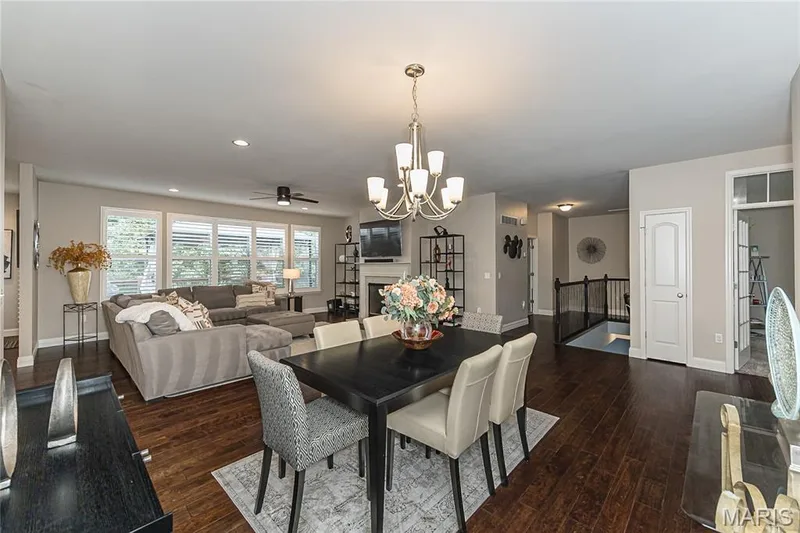 Wood-finish flooring throughout, with a decorative chandelier illuminating the dining area — 1229 Cashmere Lane, St Peters, MO 63376