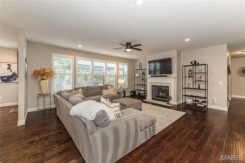 Hardwood flooring throughout, a white-mantled fireplace, abundant natural light from multiple windows, and recessed lighting — 1229 Cashmere Lane, St Peters, MO 63376