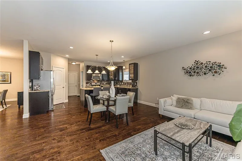 Wood-finish flooring throughout, recessed lighting, dark cabinetry, stainless steel appliances, and pendant lighting — 1229 Cashmere Lane, St Peters, MO 63376