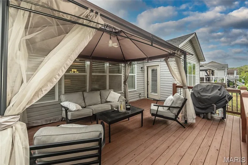 Expansive outdoor deck featuring wood-finish flooring, a covered gazebo, and a ceiling fan — 1229 Cashmere Lane, St Peters, MO 63376