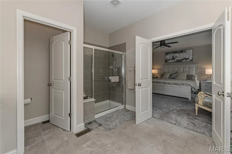 Tiled flooring leading to a walk-in shower with glass enclosure and tiled walls — 1229 Cashmere Lane, St Peters, MO 63376