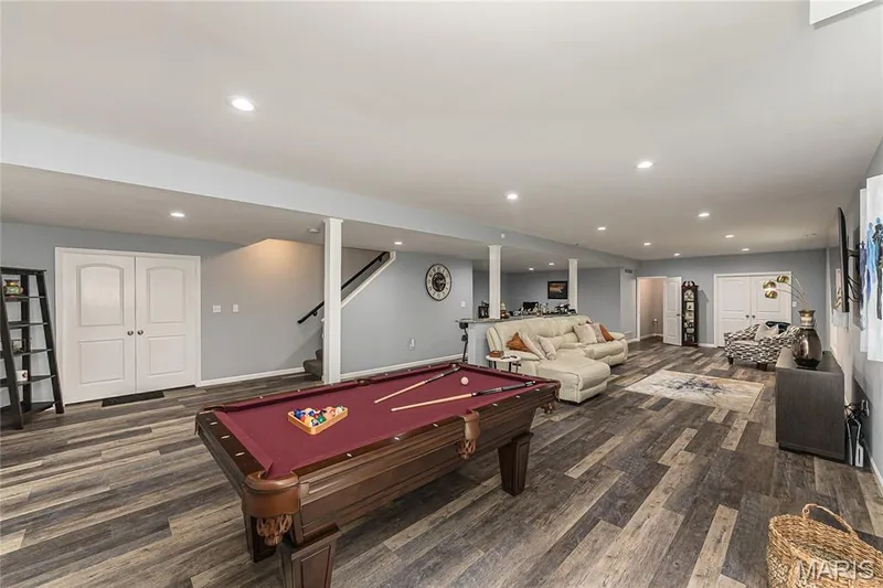 Spacious recreational area featuring wood-finish flooring, recessed lighting, and light gray wall tones — 1229 Cashmere Lane, St Peters, MO 63376