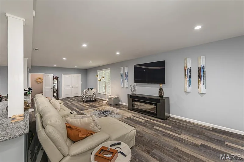 Recessed lighting illuminates the expansive living area with wood-finish flooring — 1229 Cashmere Lane, St Peters, MO 63376