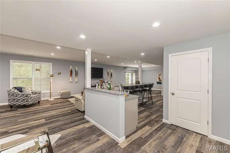 Recessed lighting, wood-finish flooring, white trim, and a built-in bar with a stone countertop — 1229 Cashmere Lane, St Peters, MO 63376