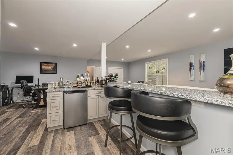 Wet bar with granite-look countertop, integrated beverage refrigerator, built-in cabinetry, and recessed lighting — 1229 Cashmere Lane, St Peters, MO 63376