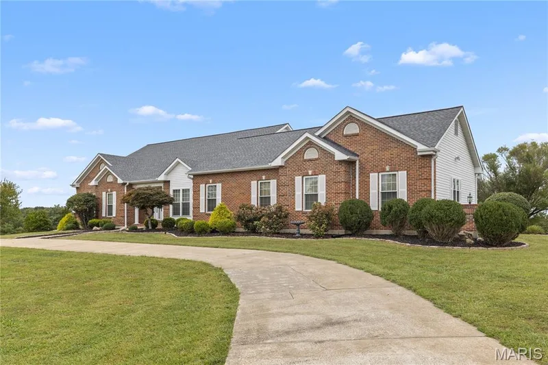 Brick veneer exterior with white shutters, multiple gables, and dark gray roofing — 104 Wolf Trail Court, Defiance, MO 63341