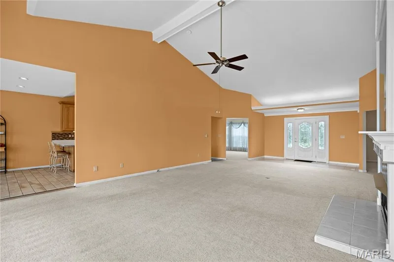 Vaulted ceilings with exposed beams, ceiling fan, and decorative double entry doors — 104 Wolf Trail Court, Defiance, MO 63341