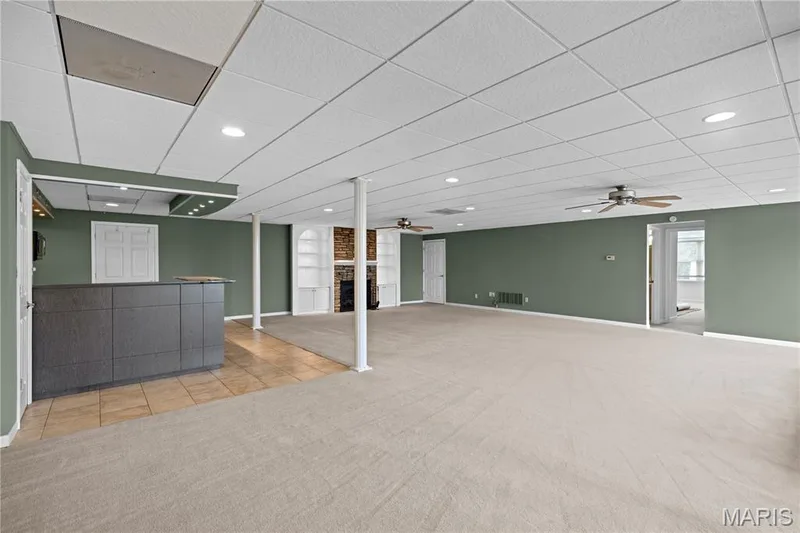 Spacious recreation room featuring a built-in bar, recessed lighting, and ceiling fans — 104 Wolf Trail Court, Defiance, MO 63341