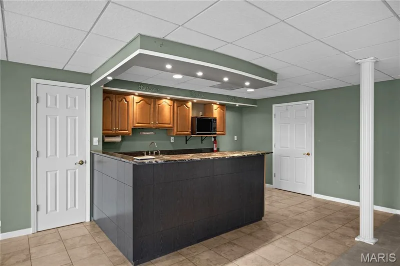 Wet bar featuring an integrated sink, wood cabinetry, and recessed lighting — 104 Wolf Trail Court, Defiance, MO 63341