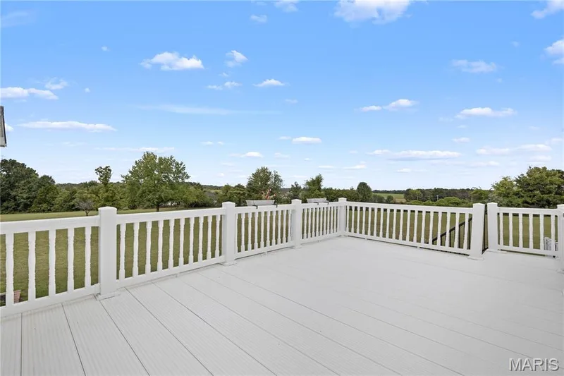 Expansive outdoor deck with white railing, composite decking, and a wide rural landscape — 104 Wolf Trail Court, Defiance, MO 63341