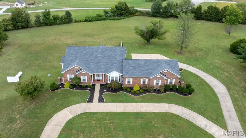 Brick exterior with white trim, a dark gray shingle roof, and a concrete driveway — 104 Wolf Trail Court, Defiance, MO 63341