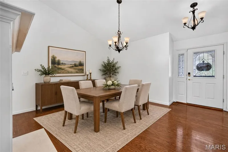 Vaulted ceiling, wood-finish flooring, white walls, and a white entry door with decorative glass panels — 20 Autumn Ridge Drive #83B, O'Fallon, MO 63366