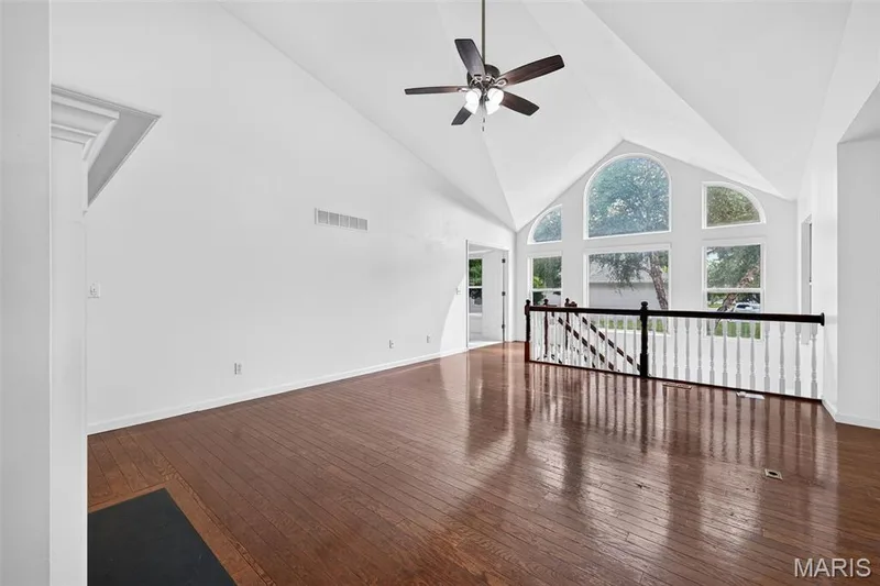 Vaulted ceiling with a ceiling fan, wood-finish flooring, and arched window — 20 Autumn Ridge Drive #83B, O'Fallon, MO 63366
