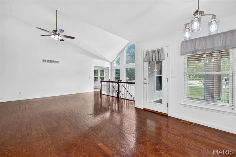 Vaulted ceilings, wood-finish flooring, ceiling fan, and a transom window with a full-light door — 20 Autumn Ridge Drive #83B, O'Fallon, MO 63366