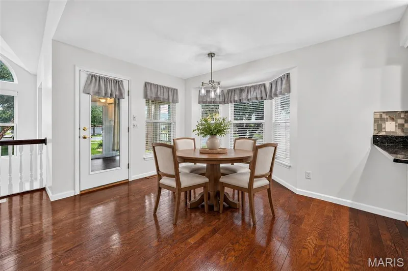 Hardwood flooring, bay window with blinds, glass-paned exterior door, recessed lighting, and a contemporary pendant light fixture — 20 Autumn Ridge Drive #83B, O'Fallon, MO 63366