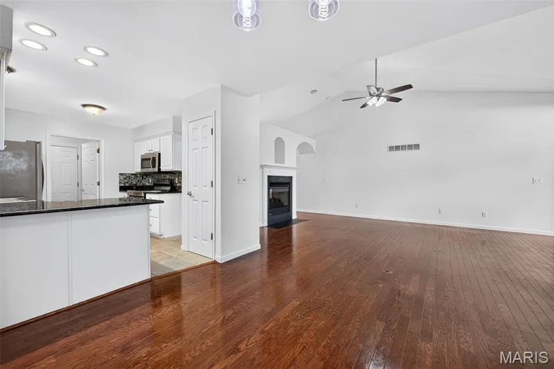 Wood-finish flooring, vaulted ceiling, built-in fireplace, recessed lighting, and a ceiling fan — 20 Autumn Ridge Drive #83B, O'Fallon, MO 63366
