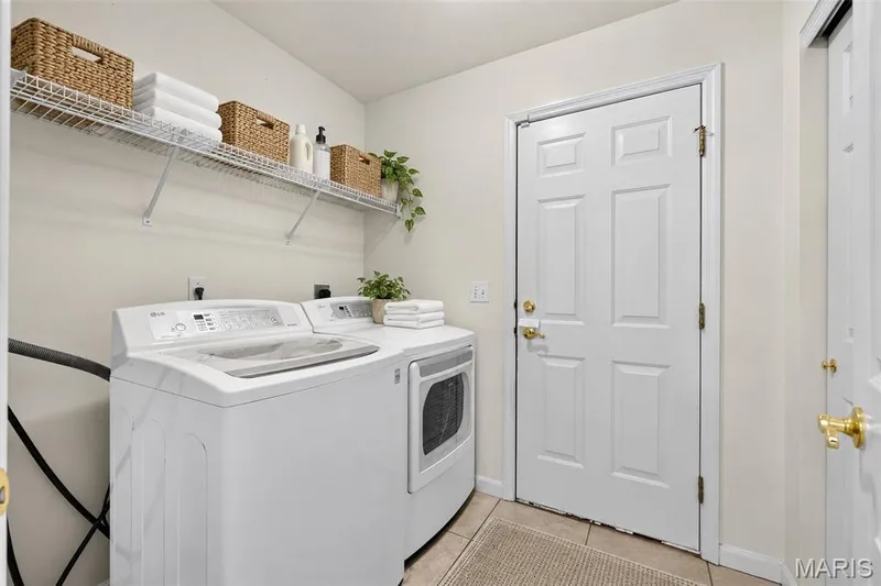 Laundry area with tile flooring and overhead wire shelving — 20 Autumn Ridge Drive #83B, O'Fallon, MO 63366