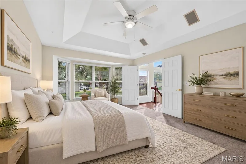 Vaulted tray ceiling with a ceiling fan, bay windows, and carpet flooring — 20 Autumn Ridge Drive #83B, O'Fallon, MO 63366