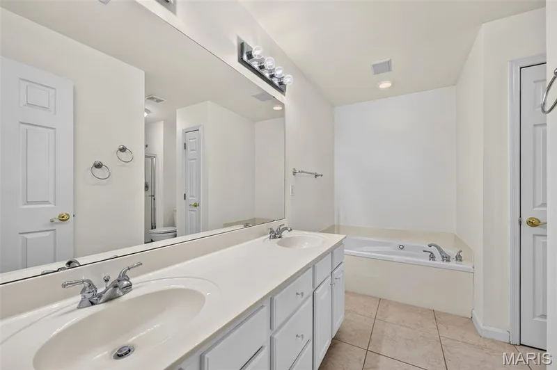 Dual vanity with white cabinetry and integrated sinks — 20 Autumn Ridge Drive #83B, O'Fallon, MO 63366