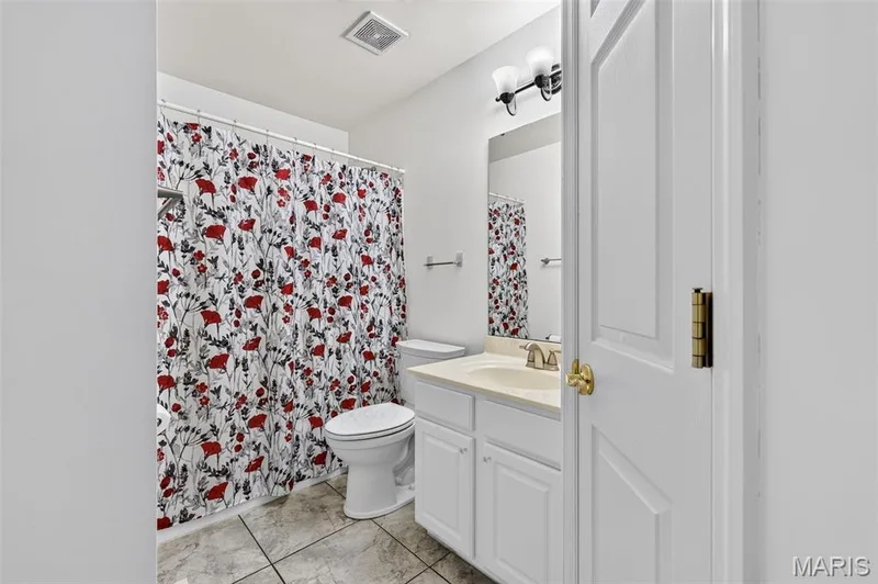 White vanity with integrated sink, rectangular mirror, and two-light vanity fixture — 20 Autumn Ridge Drive #83B, O'Fallon, MO 63366
