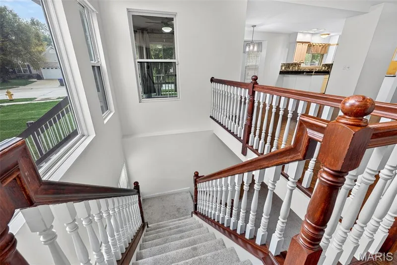 Staircase featuring wood railings and white balusters — 20 Autumn Ridge Drive #83B, O'Fallon, MO 63366