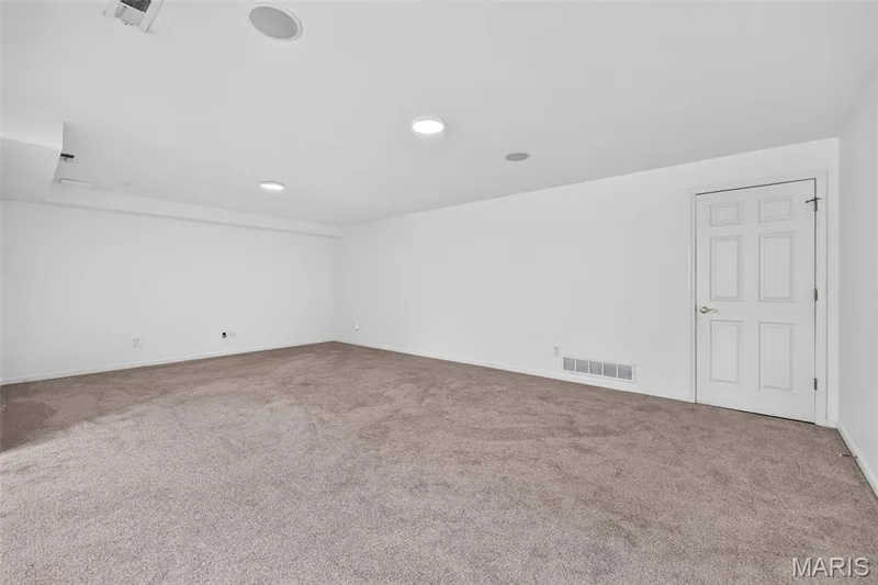 Spacious room featuring neutral carpeting, recessed lighting, and a six-panel door — 20 Autumn Ridge Drive #83B, O'Fallon, MO 63366