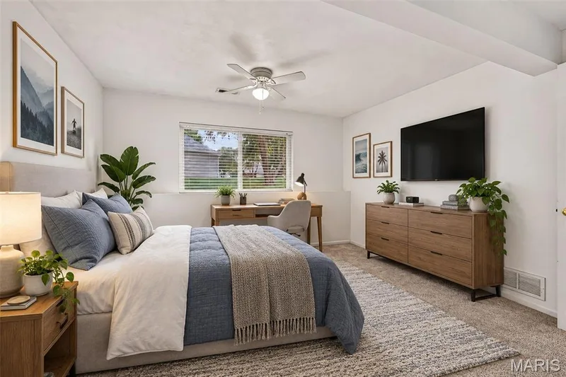 Carpeted bedroom featuring a ceiling fan, a window with blinds, and built-in wall shelving — 20 Autumn Ridge Drive #83B, O'Fallon, MO 63366