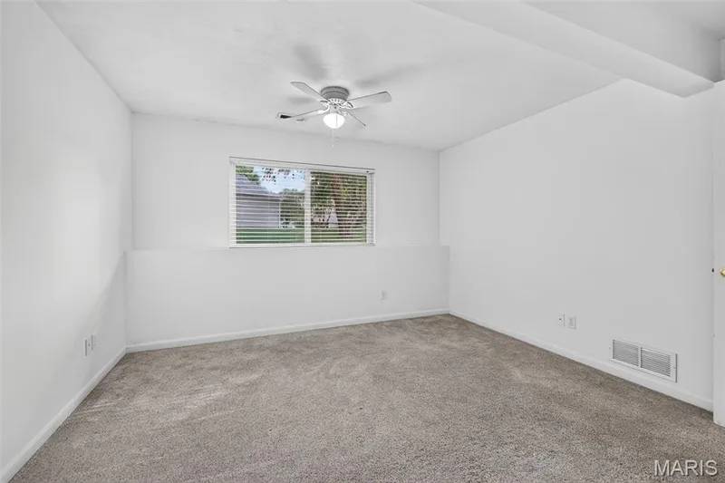 Carpeted flooring, white walls, window with horizontal blinds, and a ceiling fan with integrated lighting — 20 Autumn Ridge Drive #83B, O'Fallon, MO 63366