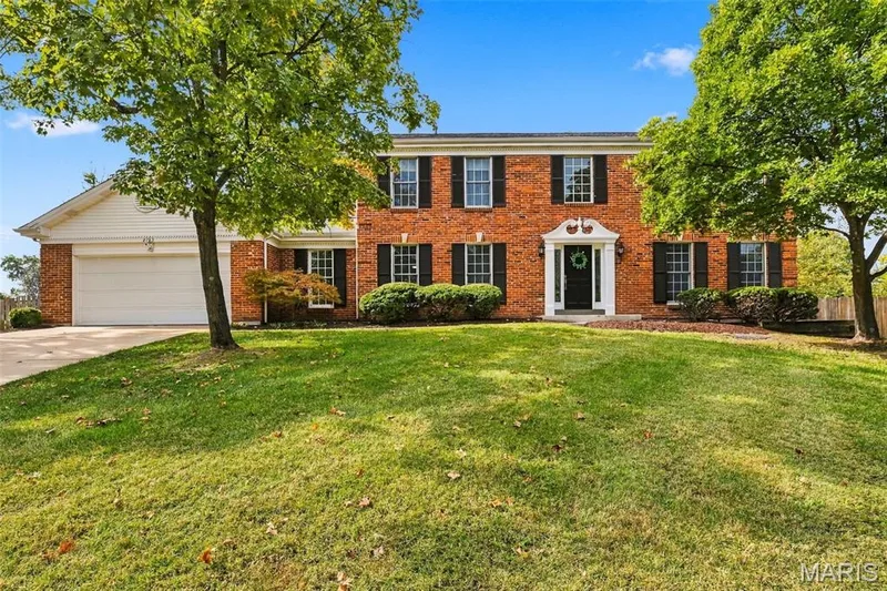 Brick exterior with white trim, attached two-car garage, and mature landscaping — 2785 Sun Meadow Drive, Wildwood, MO 63005