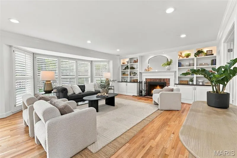 Hardwood flooring throughout, recessed lighting, built-in shelving with cabinetry, brick fireplace, and bay windows with plantation shutters — 2785 Sun Meadow Drive, Wildwood, MO 63005