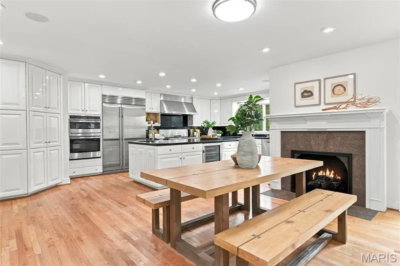 Gourmet kitchen with stainless steel appliances, white cabinetry, a central island with dark countertops, and wood-finish flooring — 2785 Sun Meadow Drive, Wildwood, MO 63005