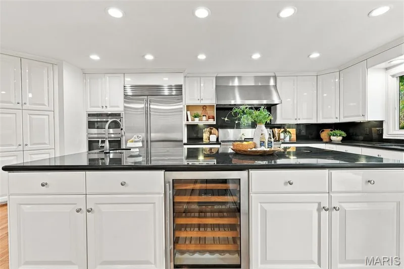 White cabinetry, recessed lighting, black countertops, stainless steel appliances, and a built-in wine refrigerator — 2785 Sun Meadow Drive, Wildwood, MO 63005
