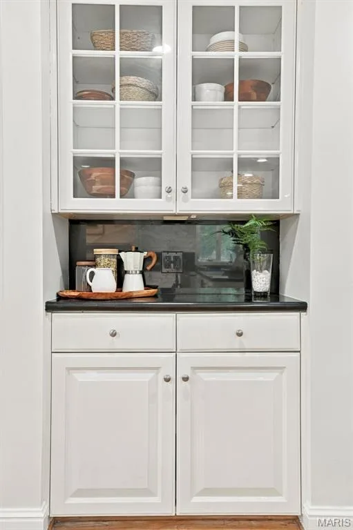 White shaker-style upper cabinets with glass panels, a dark countertop, and matching lower cabinetry — 2785 Sun Meadow Drive, Wildwood, MO 63005