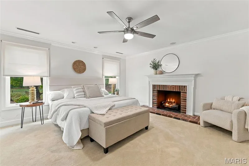 Recessed lighting, ceiling fan with integrated light, brick-surround fireplace with mantel, crown molding, and light-toned carpeting — 2785 Sun Meadow Drive, Wildwood, MO 63005
