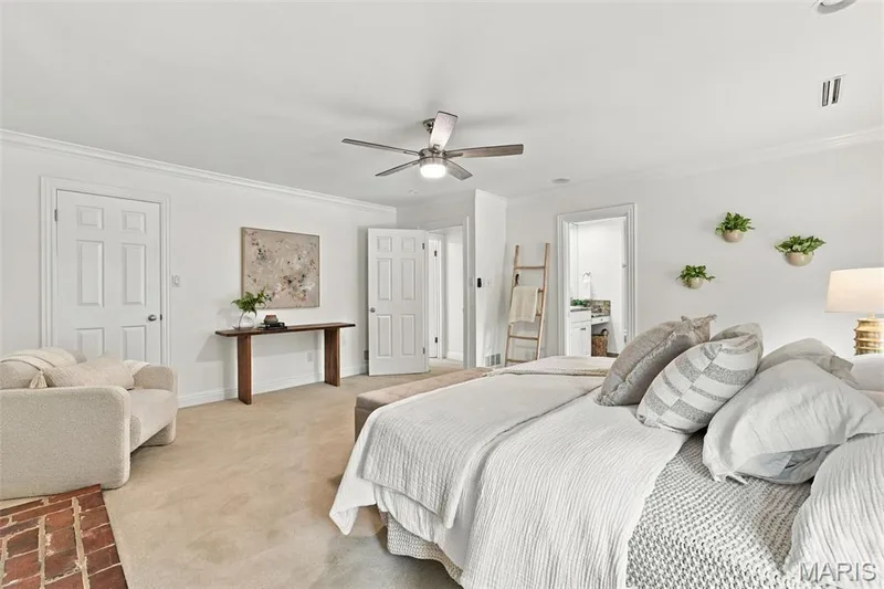 Carpeted flooring, crown molding, white paneled doors, ceiling fan with integrated lighting, and brick hearth — 2785 Sun Meadow Drive, Wildwood, MO 63005