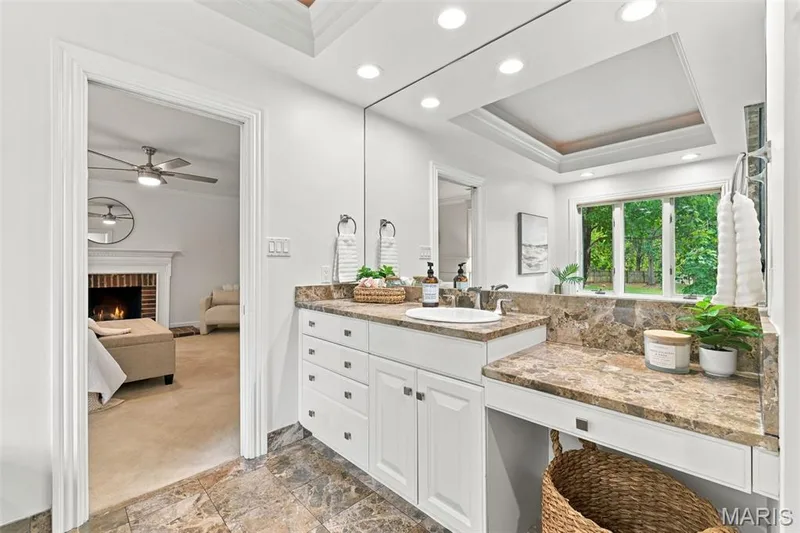 Vanity with a built-in dressing area, single basin, and stone countertops — 2785 Sun Meadow Drive, Wildwood, MO 63005