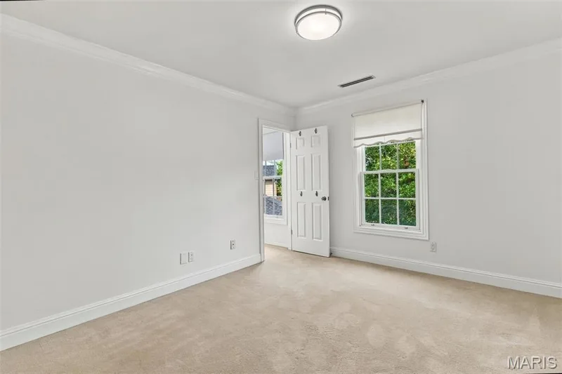 Neutral-toned carpet flooring with white baseboards and crown molding — 2785 Sun Meadow Drive, Wildwood, MO 63005