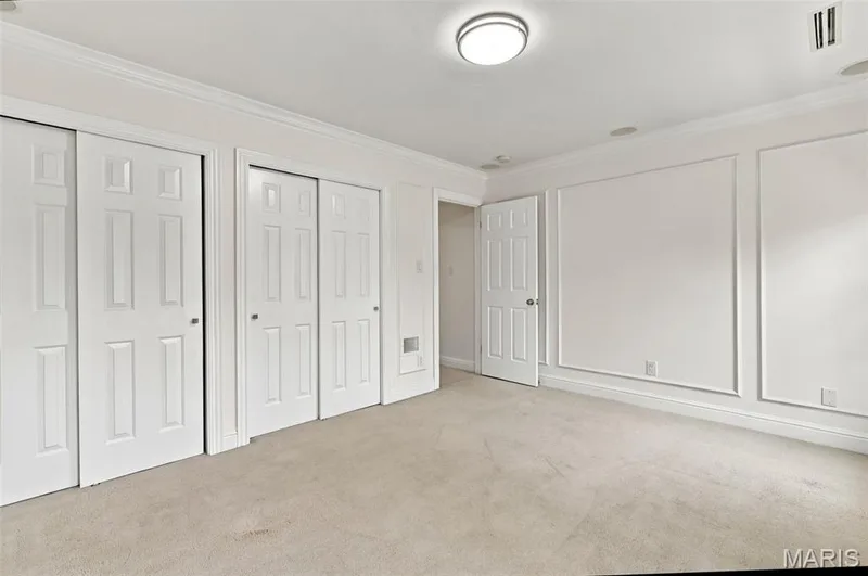 Wall panel molding details, flush mount ceiling lighting, crown molding, paneled doors, and carpeted flooring — 2785 Sun Meadow Drive, Wildwood, MO 63005