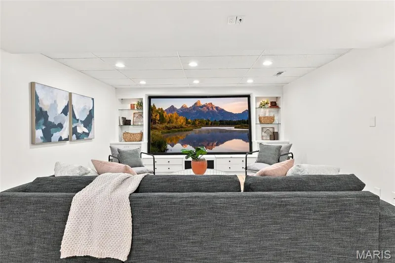 Recessed lighting illuminates the entertainment area with built-in shelving and a large media display — 2785 Sun Meadow Drive, Wildwood, MO 63005