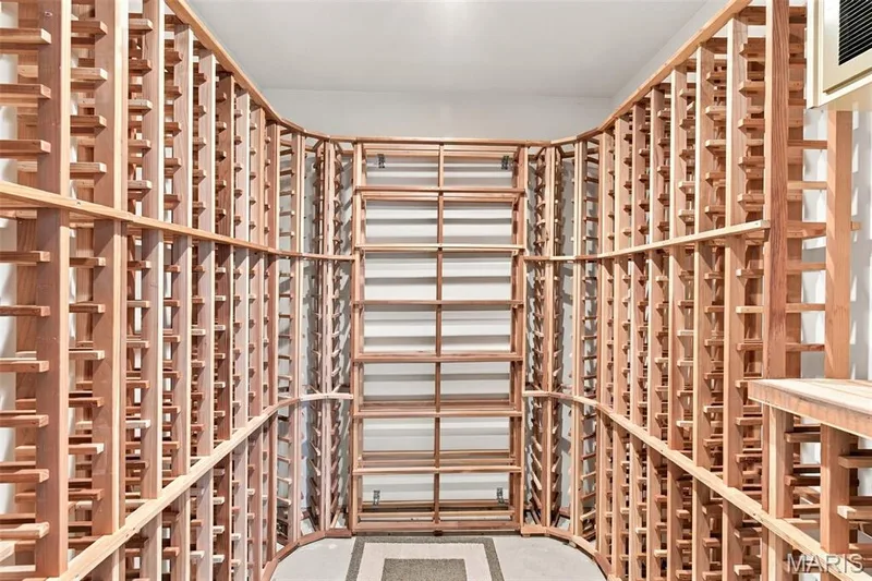 Walk in wine cellar room with Curved wood-finish wine racks, integrated shelving, ample storage capacity, recessed ceiling lighting — 2785 Sun Meadow Drive, Wildwood, MO 63005