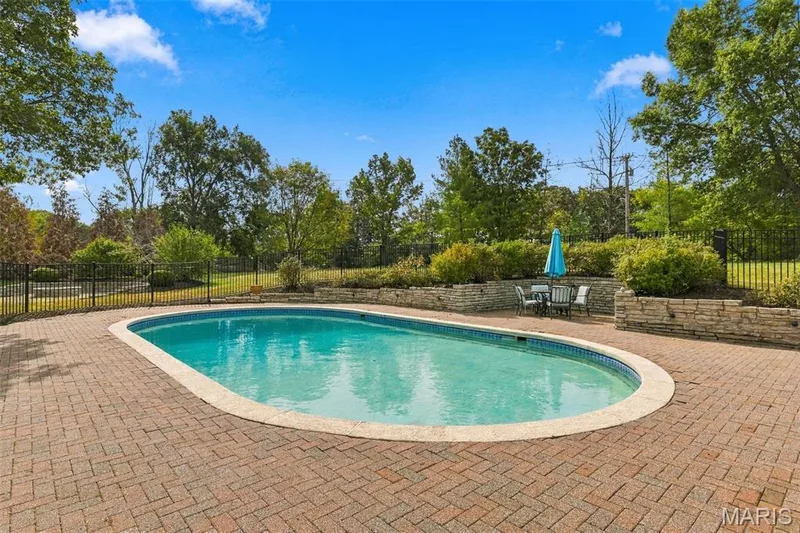 Oval-shaped inground pool with a stone coping and a brick paver surround — 2785 Sun Meadow Drive, Wildwood, MO 63005